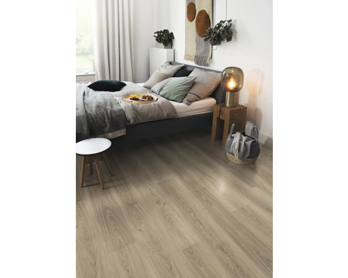 Světlá laminátová podlaha v ložnici s postelí, nočním stolkem a dekoracemi.