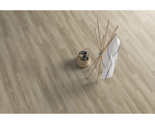 Světlá prkna z vinylové podlahy se vzhledem dřeva, šatna a koš na prádlo.