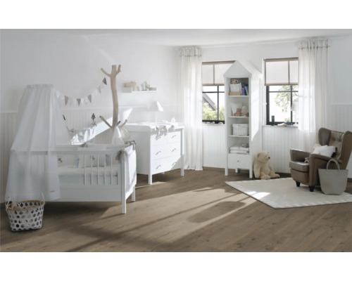 Světlý dětský pokoj s dětskou postýlkou, přebalovacím pultem, regálem a křeslem