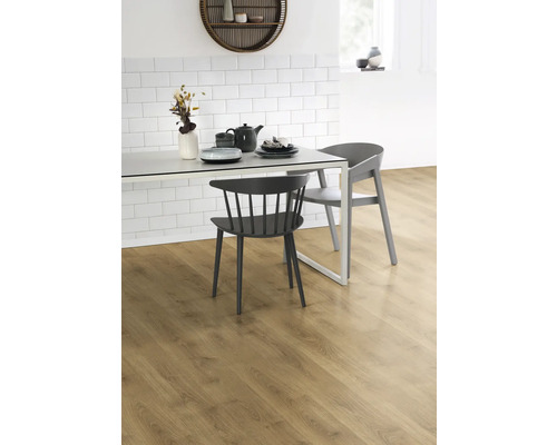 Jídelní stůl s nádobím a židlemi na laminátové podlaze