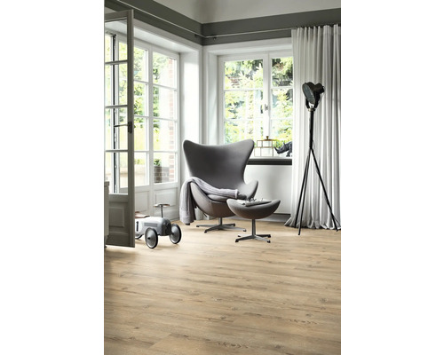 Světlý obývací pokoj s dřevěnou podlahou, křeslem a denním světlem