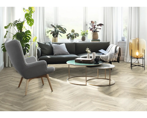 Obývací pokoj s šedou pohovkou, křeslem a dekorativními předměty na stole