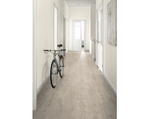 Chodba se světlou laminátovou podlahou, bílými stěnami a kolem