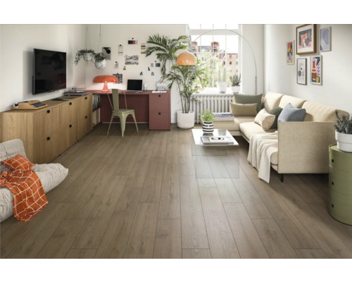 Světlý obývací pokoj s dřevěnou podlahou, pohovkou, psacím stolem a dekoracemi pro útulnou atmosféru.