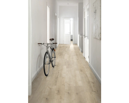 Chodba se světle dřevěnou podlahou, bílými stěnami a jízdním kolem