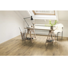 Světlý pracovní prostor se stolem, lampou a dřevěnou podlahou