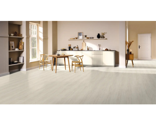 Světlá kuchyně s dřevěnou podlahou, jídelním stolem a židlemi.