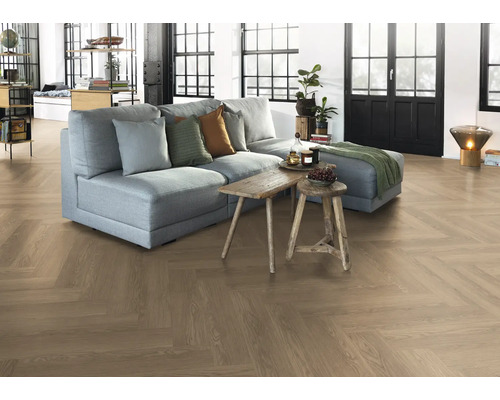 Obývací pokoj s parketovou podlahou ve vzoru rybí kosti, pohovkou a dřevěnými stoly.