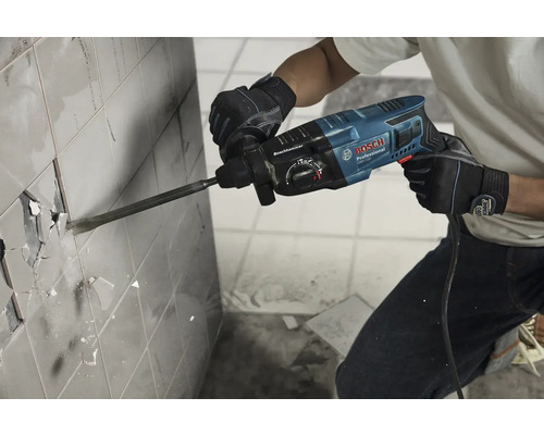 Osoba odstraňuje dlaždice pomocí vrtacího kladiva značky Bosch