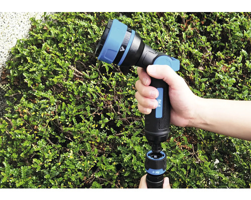 Stříkací pistole na zahradní hadici s nastavitelnou stříkací hlavou v ruce