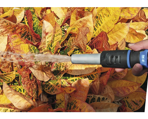 Zahradní scéna s ruční sprchou postřikující listy