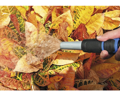 Zavlažování zahrady zahradní hadicí na listí