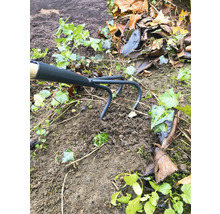 Zahradní motyka používaná mezi hlínou a rostlinami