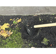 Motyka se dřevěnou násadou v záhonu