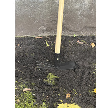 Zahradní motyka s dřevěnou násadou v zemi