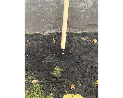 Zahradní motyka s dřevěnou násadou v zemi