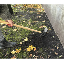 Práce na zahradě s kombinovanou motykou pro zpracování půdy