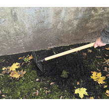 Zahradní motyka s dřevěnou rukojetí používaná k prokypřování půdy