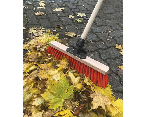 Koště s dřevěnou násadou a podzimním listím