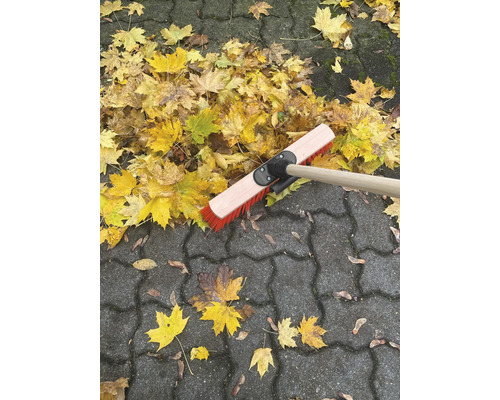 Hrábě na listí na dlažebních kostkách s podzimním listím