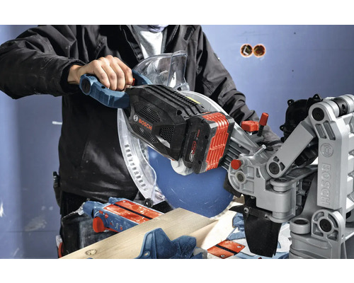 Akumulátorová okružní pila v provozu s kusem dřeva a řemeslníkem