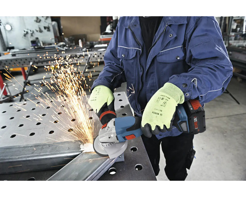 Osoba brousí kov úhlovou bruskou a nosí ochranné rukavice.