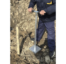 Muž hutní půdu ručním pěchovadlem