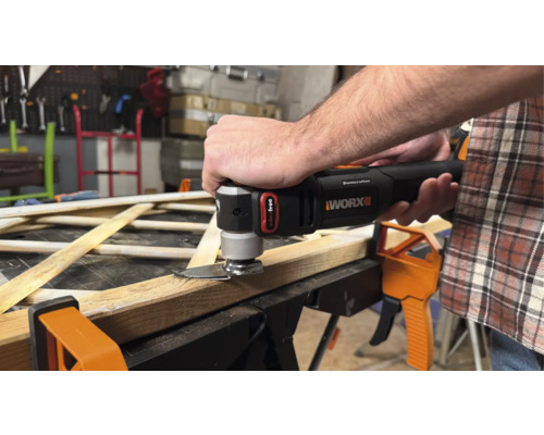 Muž řeže dřevo oscilačním multifunkčním nástrojem od společnosti Worx