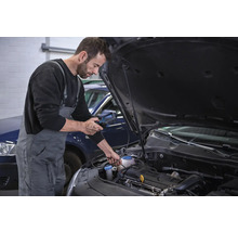 Mechanik provádí diagnostiku motoru automobilu pomocí diagnostického zařízení.