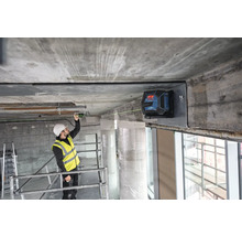 Stavební dělník používá čárový laser pro vyrovnání na staveništi.