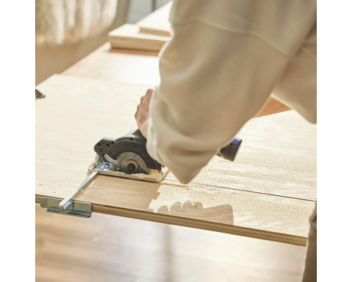 Osoba řeže dřevo kotoučovou pilou.