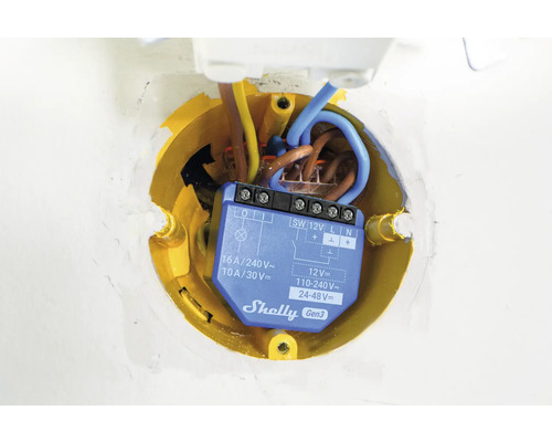 Elektrický spínač v žluté spojovací krabici s kabely