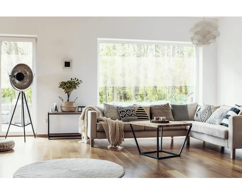 Obývací pokoj s pohovkou, polštáři, konferenčním stolkem, stojací lampou a oknem