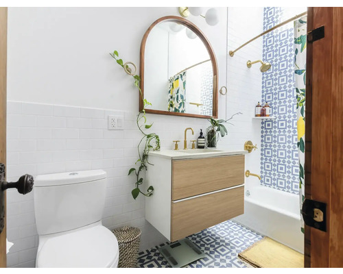 Koupelna s toaletou, umyvadlovou skříňkou, zrcadlem a vanou se sprchovým závěsem