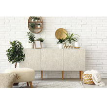 Světlý pokoj s komodou, rostlinami a dekorací před bílou cihlovou zdí