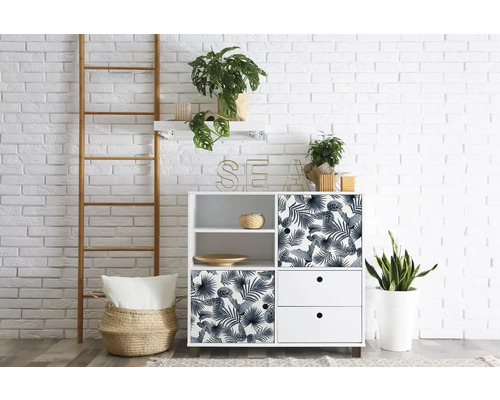 Pohled do pokoje s bílou úložnou skříní, žebříkem a pokojovými rostlinami před bílou cihlovou zdí