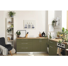 Světlá kuchyně se zelenými skříňkami, dřevěnými pracovními deskami a různými dekorativními předměty