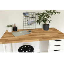 Pracovní prostor s dřevěnou deskou stolu, notebookem, rostlinou a kancelářskými potřebami