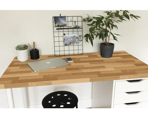 Pracovní prostor s dřevěnou deskou stolu, notebookem, rostlinou a kancelářskými potřebami