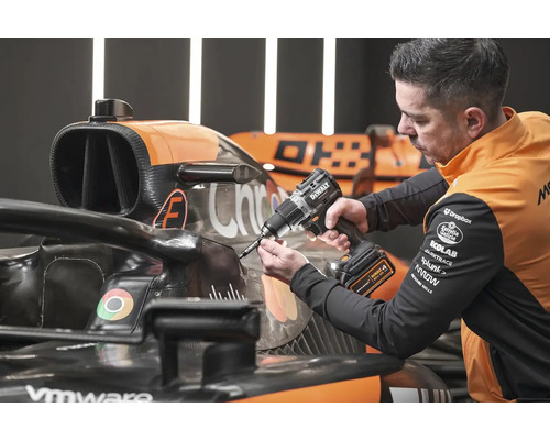 Mechanik používá akumulátorový vrtací šroubovák DeWalt na závodním autě.