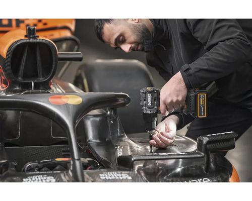 Muž připevňuje díl k závodnímu vozu pomocí akumulátorového šroubováku