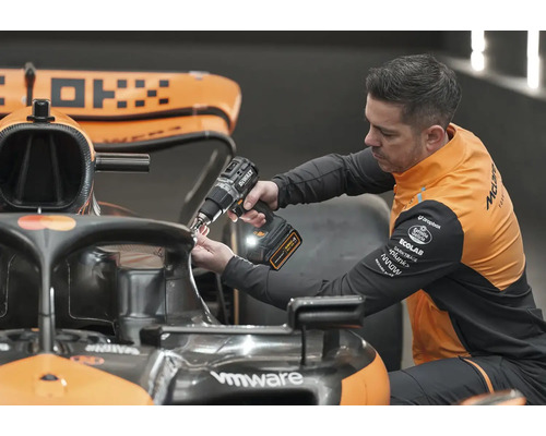 Mechanik používá akumulátorový šroubovák k práci na závodním voze Formule 1.