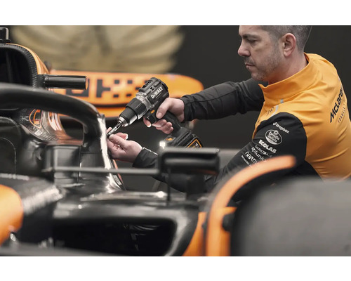 Mechanik používá akumulátorový šroubovák DeWalt na závodním autě.