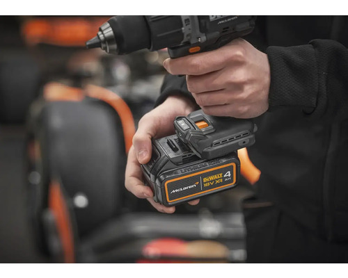 Osoba drží akumulátorový vrtací šroubovák s 18voltovou baterií