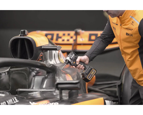 Mechanik používá akumulátorový rázový utahovák DeWalt na závodním autě.