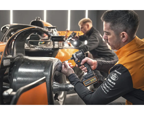 Mechanik připevňuje součástku k závodnímu vozu pomocí akumulátorového rázového utahováku DeWalt.