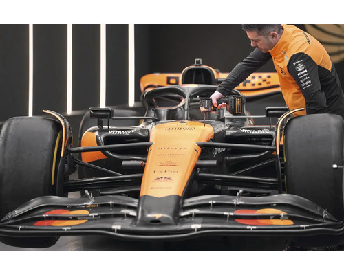 Mechanik pracuje s akumulátorovým šroubovákem na závodním voze Formule 1.