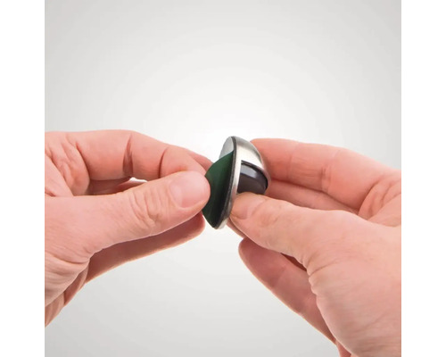 Dveřní zarážka z nerezové oceli je držena rukama