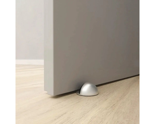 Kovový dveřní doraz na podlaze před dveřmi