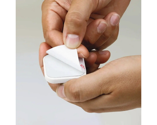 Ruce odstraňují ochrannou fólii z lepicí podložky